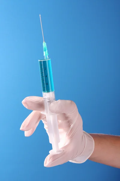 Spritze in Arzthandlung vor blauem Hintergrund — Stockfoto
