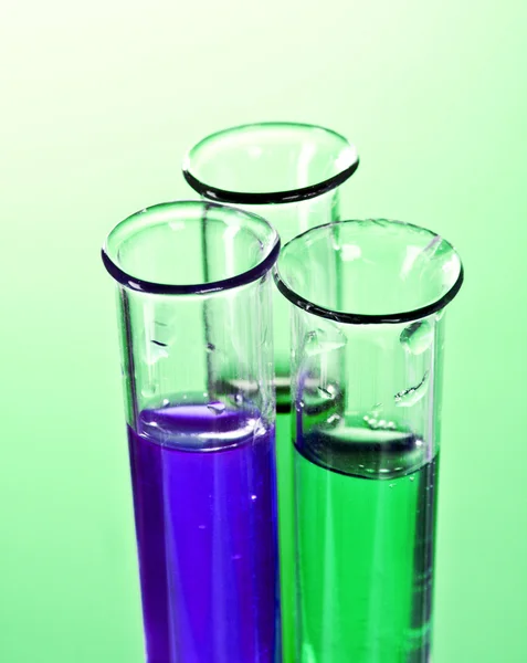 Test tubes on green background — Stock Photo, Image