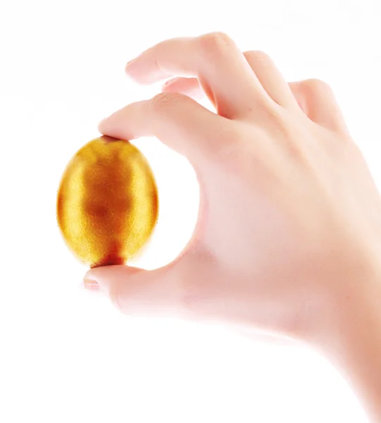 Ovo de ouro na mão isolado em branco — Fotografia de Stock