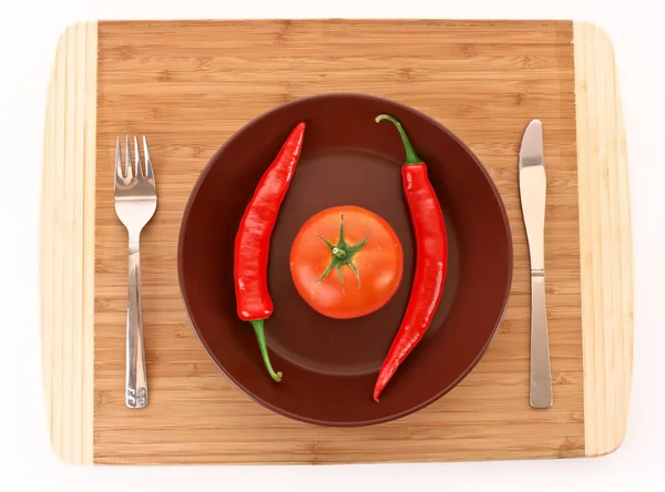 Deska s paprikou, rajčaty, vidličkou a nožem izolovaných na bílém — Stock fotografie