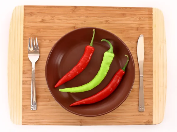 Teller mit Pfeffer, Gabel und Messer isoliert auf weiß — Stockfoto