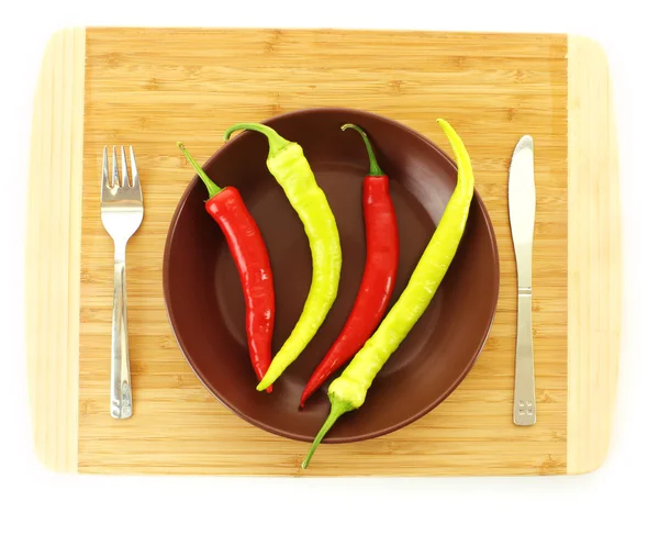 Piatto con pepe, forchetta e coltello isolato su bianco — Foto Stock
