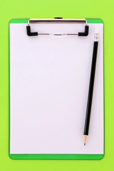 Klemmbrett und Bleistift auf grünem Hintergrund — Stockfoto