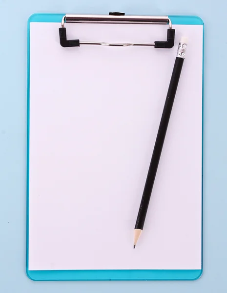 Clipboard e lápis sobre fundo azul — Fotografia de Stock