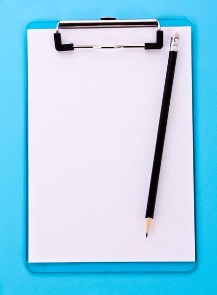 Буфер обмена и карандаш на синем фоне — стоковое фото