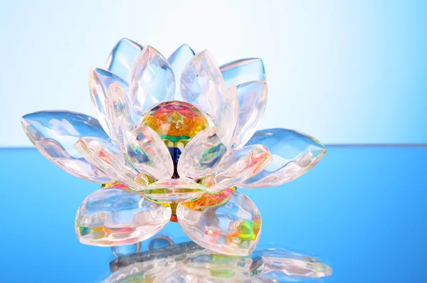 Glass lotus flower on blue background — Stock Photo, Image