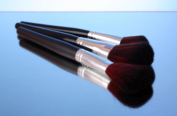 Cosmetic brushes on blue background — Stock Photo, Image