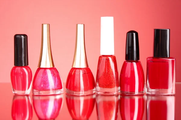 Group of nail polishes on red background — Stock Photo, Image