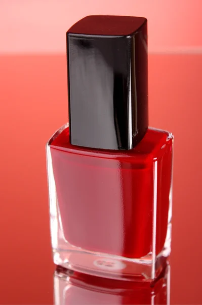Różowy lakier do paznokci na czerwonym tle — Zdjęcie stockowe