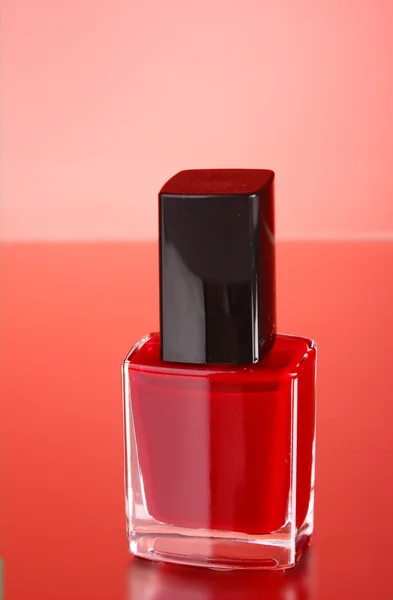Rosa Nagellack auf rotem Hintergrund — Stockfoto