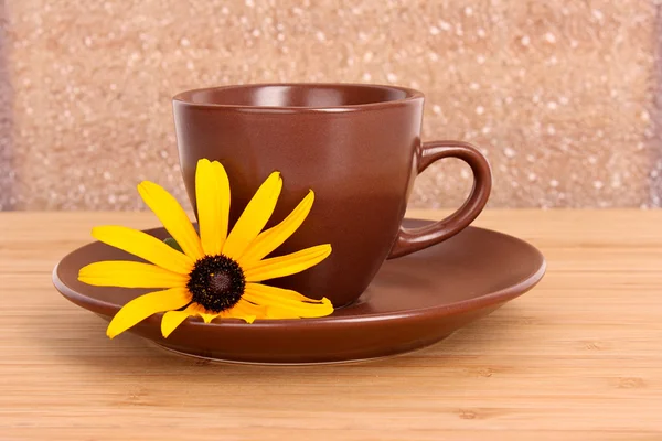 Cup of green tea on the saucer with yellow flower — Stock Photo, Image