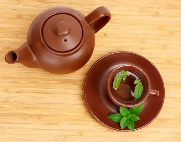 Yeşil çay tabağı üzerinde ahşap yüzeyde nane ile — Stok fotoğraf