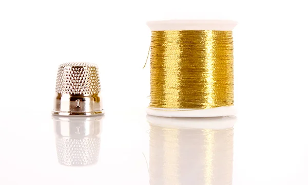 stock image Golden thread and thimble isolated on white