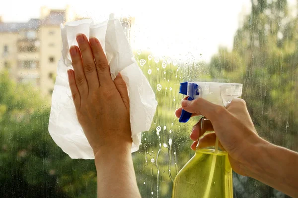 Mãos pulverizar limpar a janela — Fotografia de Stock