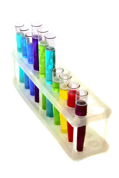 Tubos de ensaio multicoloridos no suporte isolados a branco — Fotografia de Stock
