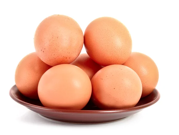 Ομάδα των αυγών της κότας καφέ στην πλάκα απομονωθεί σε λευκό — Φωτογραφία Αρχείου