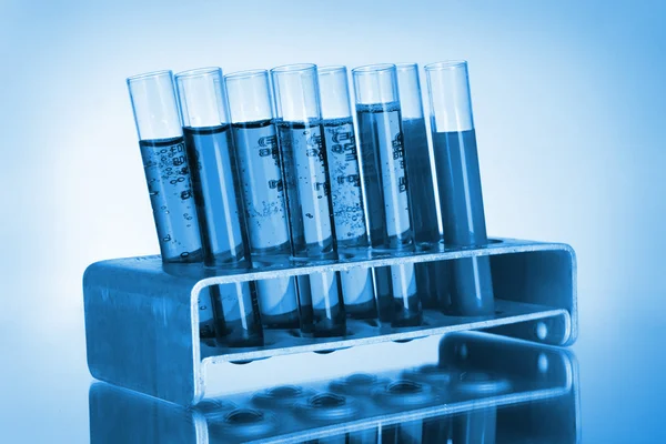 Tıbbi test tüpleri mavi zemin üzerine standı — Stok fotoğraf