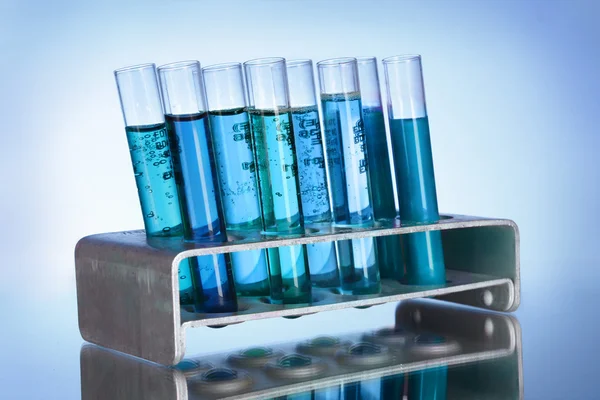 Medical test tubes in stand on blue background — Stock Photo, Image