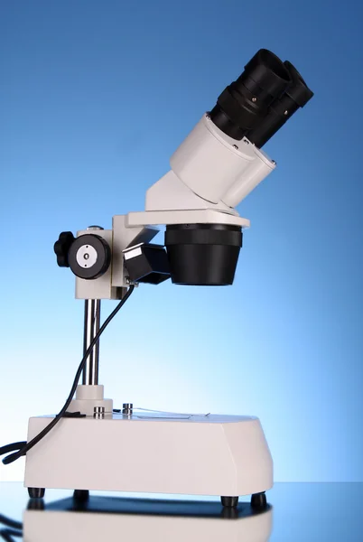 Microscópio médico em fundo azul — Fotografia de Stock