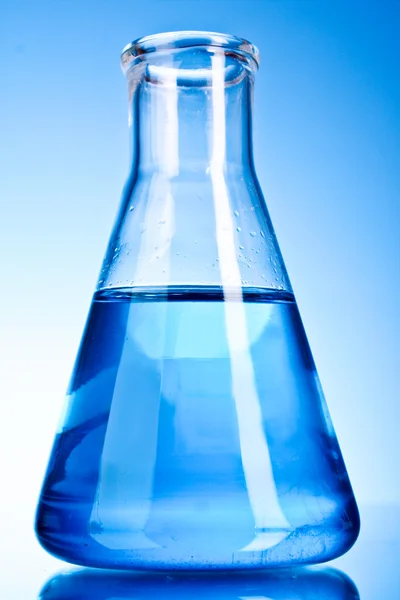 Bécher avec liquide bleu sur fond bleu — Photo