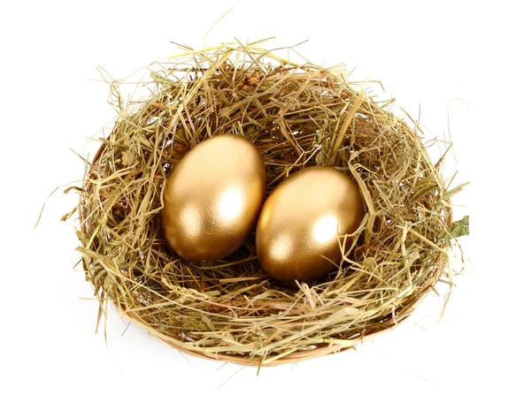 Tři zlaté vejce v travnaté hnízdo izolovaných na bílém — Stock fotografie