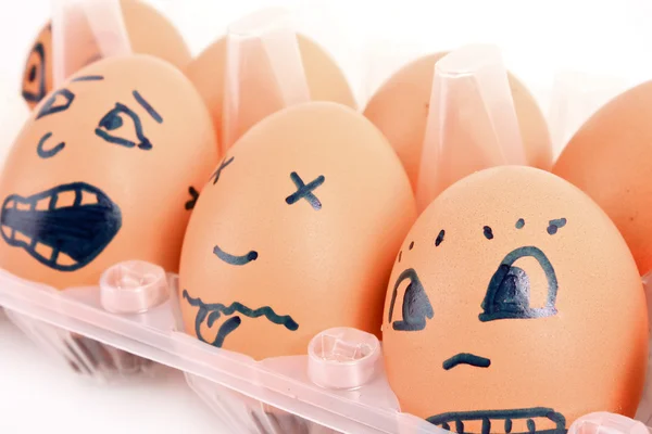 Groupe d'œufs de poule brune avec différents visages dans la boîte — Photo
