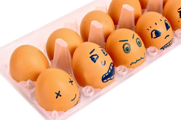 Grupo de ovos de galinha marrom com diferentes rostos na caixa isolat — Fotografia de Stock