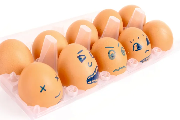 Groupe d'œufs de poule brune avec différents visages dans la boîte isolat — Photo