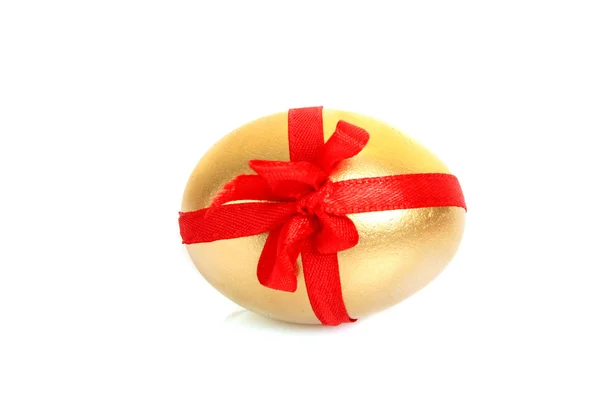 Zlaté vejce s červeným pruhem, izolované na bílém — Stock fotografie