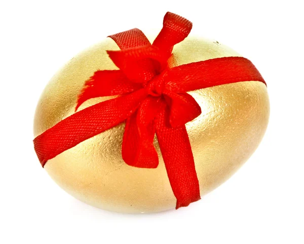 Złote jajko z czerwonym paskiem na białym tle — Zdjęcie stockowe