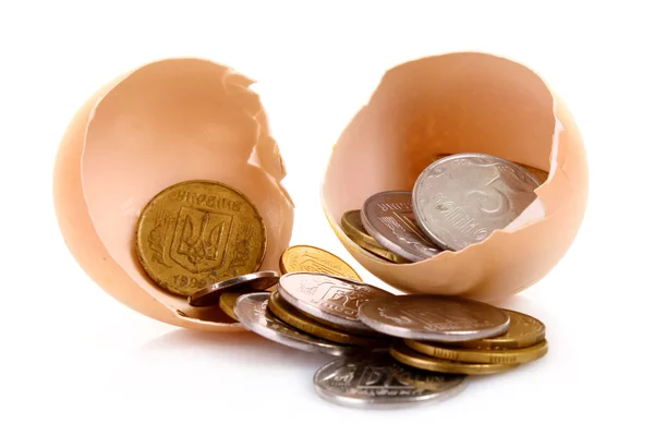 Одно разбитое куриное яйцо и украинские монеты, изолированные на белом — стоковое фото