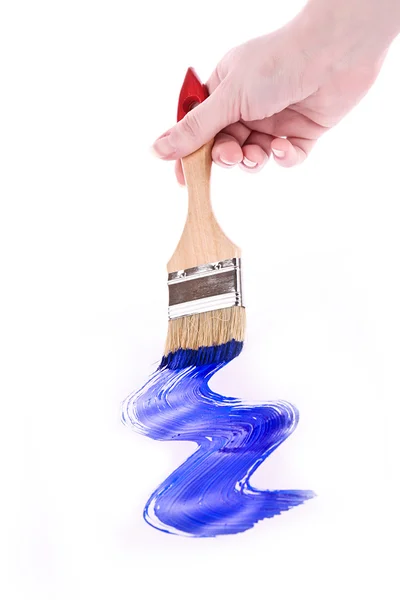 Рука з пензлем і синьою фарбою ізольовані на білому — стокове фото