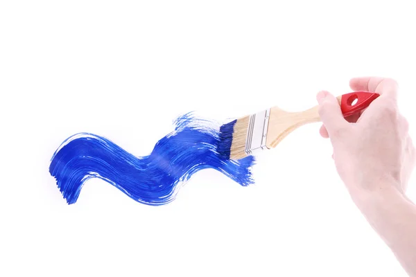 Fırça ve üzerinde beyaz izole mavi boya ile el — Stok fotoğraf