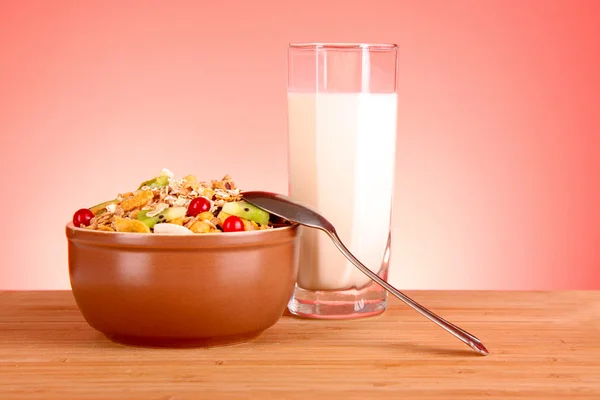 Müsli och mjölk på röd bakgrund — Stockfoto