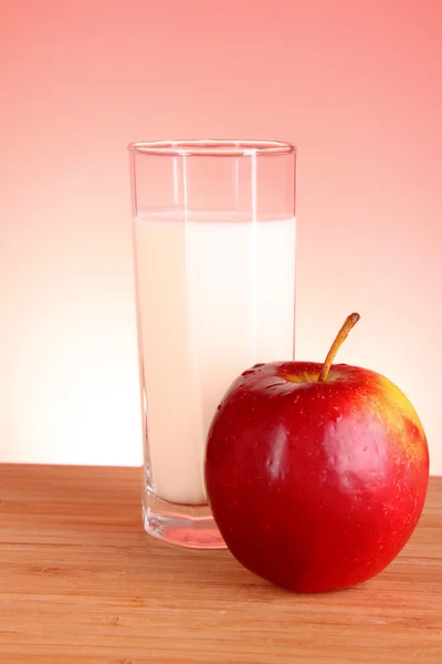 アップルと赤の背景にミルク — ストック写真