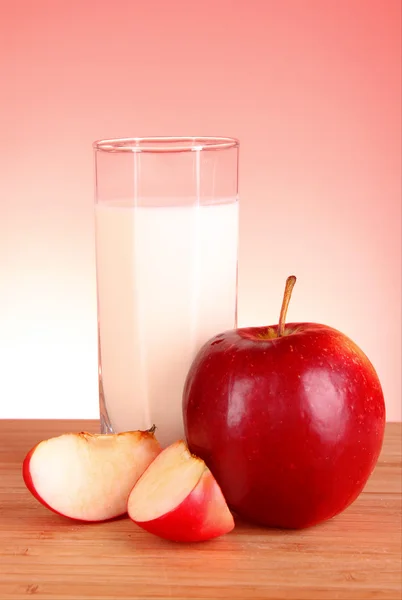 Apple a mléko na červeném pozadí — Stock fotografie
