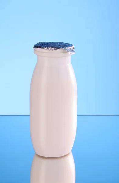 Botella de leche sobre fondo azul — Foto de Stock