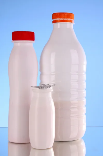 Flaschen Milch auf blauem Hintergrund — Stockfoto