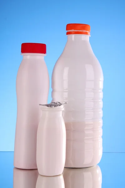 Botellas de leche sobre fondo azul — Foto de Stock