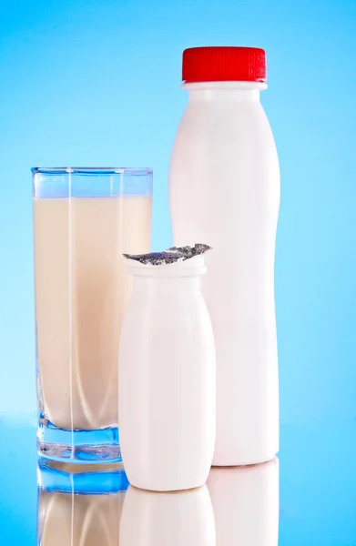 Botellas de leche sobre fondo azul — Foto de Stock