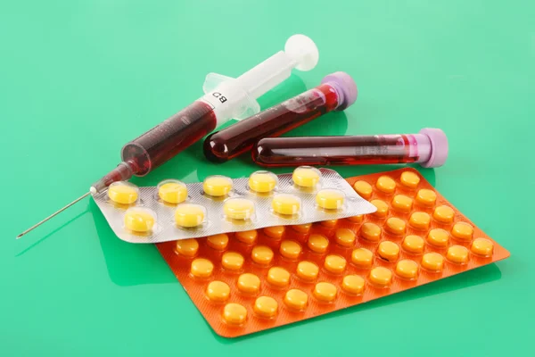 Lékařské zkumavky s krví a léků na zelené — Stock fotografie