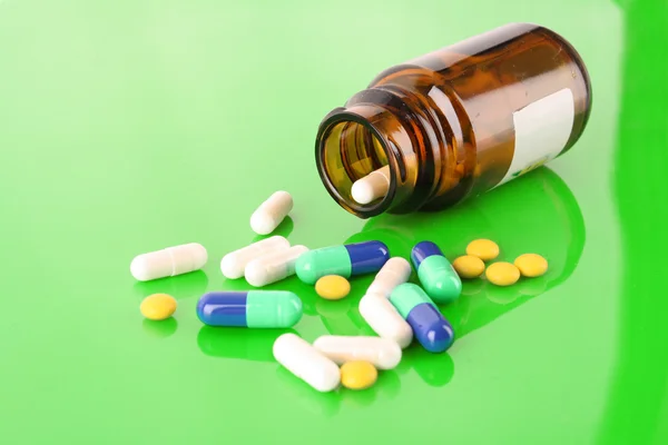 Frasco de la píldora con píldoras de color verde —  Fotos de Stock