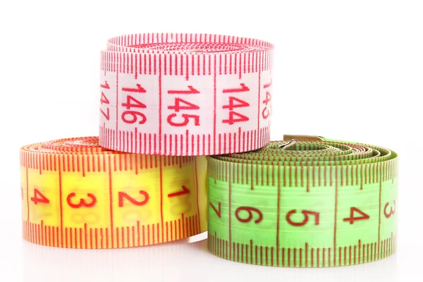 Multicoloured measuring tapes isolated on white Stock Photo