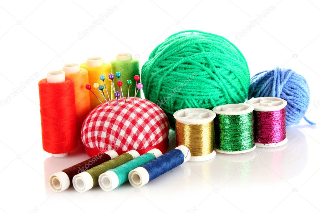 Coloured bobbins of threads, woolen balls and cushion for pins