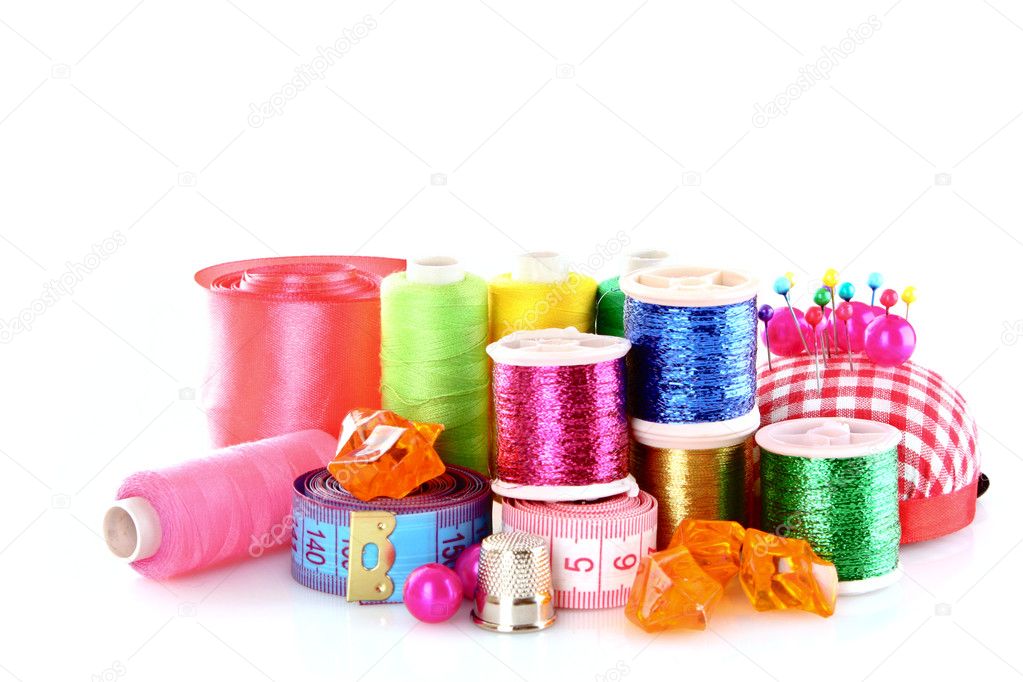 Coloured bobbins of threads, woolen balls and cushion for pins i