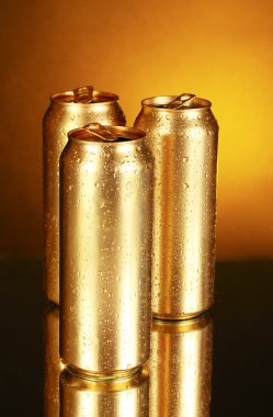Golden tin cans on yellow background with reflection clipart