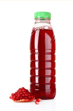 Sliced pomergranate and bottle of juice isolated on white clipart