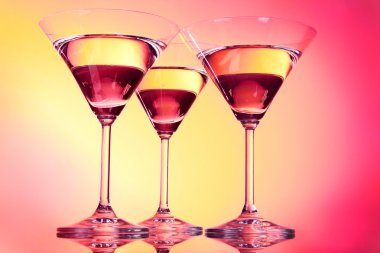 Three martini glasses on red background