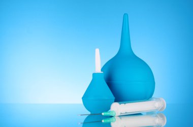 Blue rubber pear and syringe. Clyster. on blue background clipart