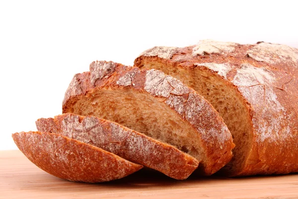 Pão fatiado com sabor em um suporte de madeira isolado em branco — Fotografia de Stock